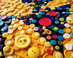 A large pile of colorful buttons on a table for Mosaic art, by Dc artist