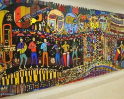 A colorful wood panel art hanging on a wall in a school in Washington DC.